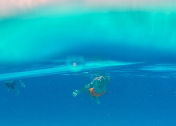 2 people surfing on 2 people surfing on water during daytime