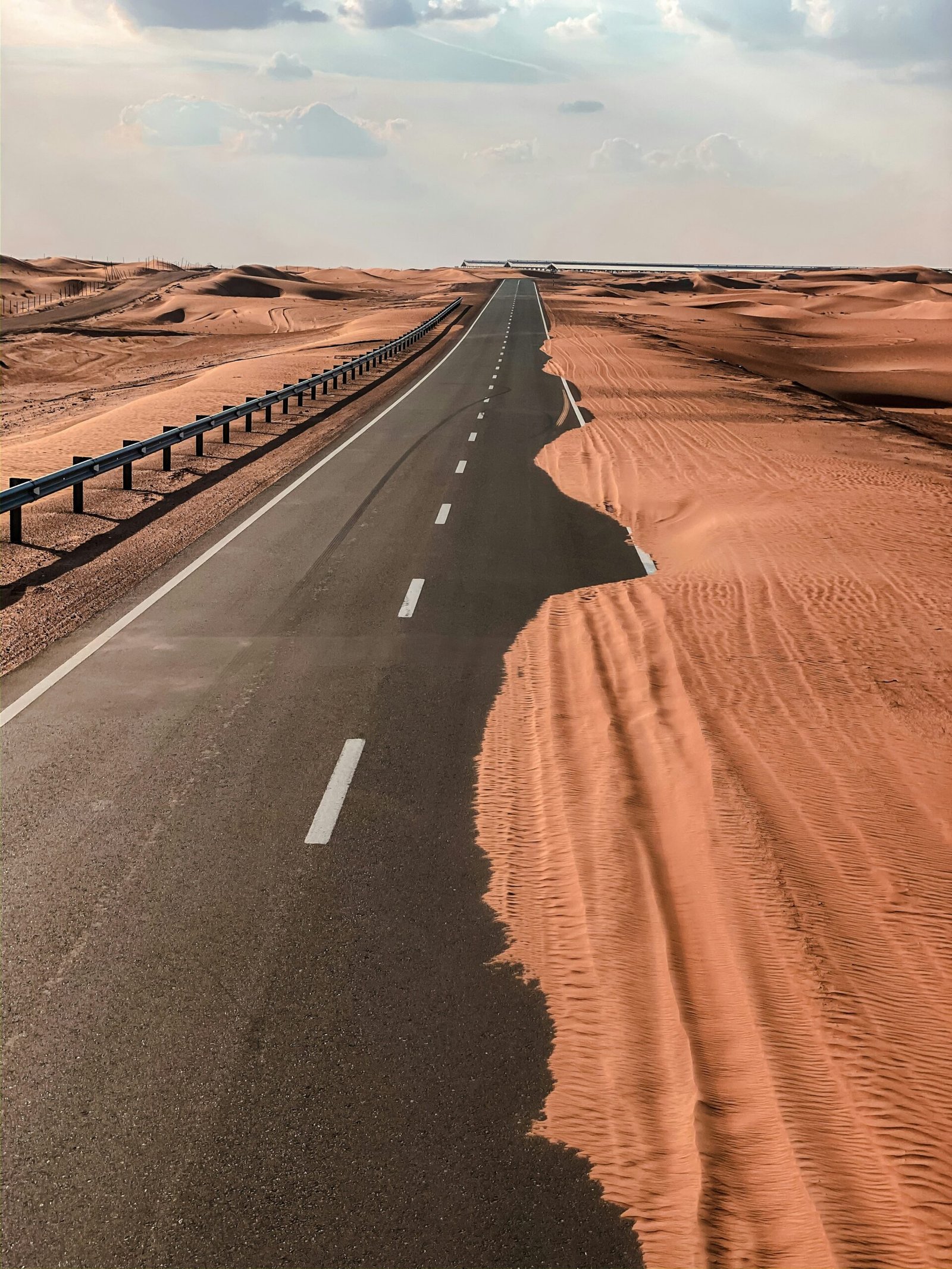 black asphalt road in the middle of desert